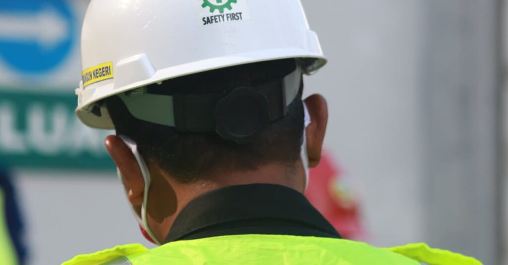 Worker with safety vest and helmet at a construction site in Central Java, Indonesia.